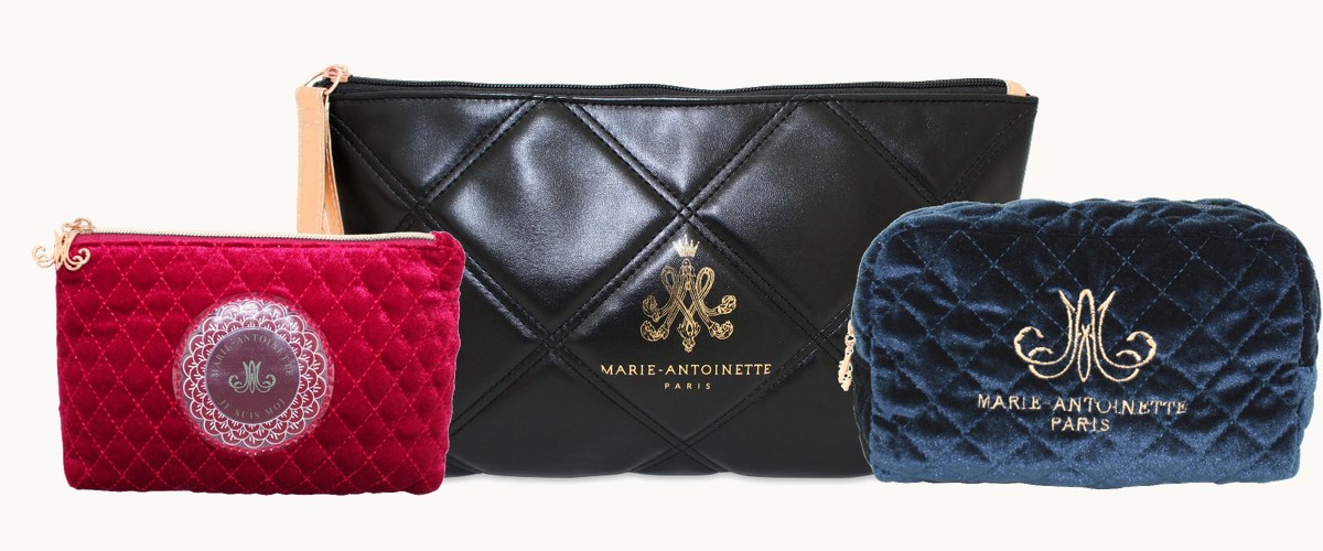 Três necessaires Marie-Antoinette: veludo matelassê vinho, couro matelassê preto e veludo azul-marinho, cada uma com o monograma dourado
